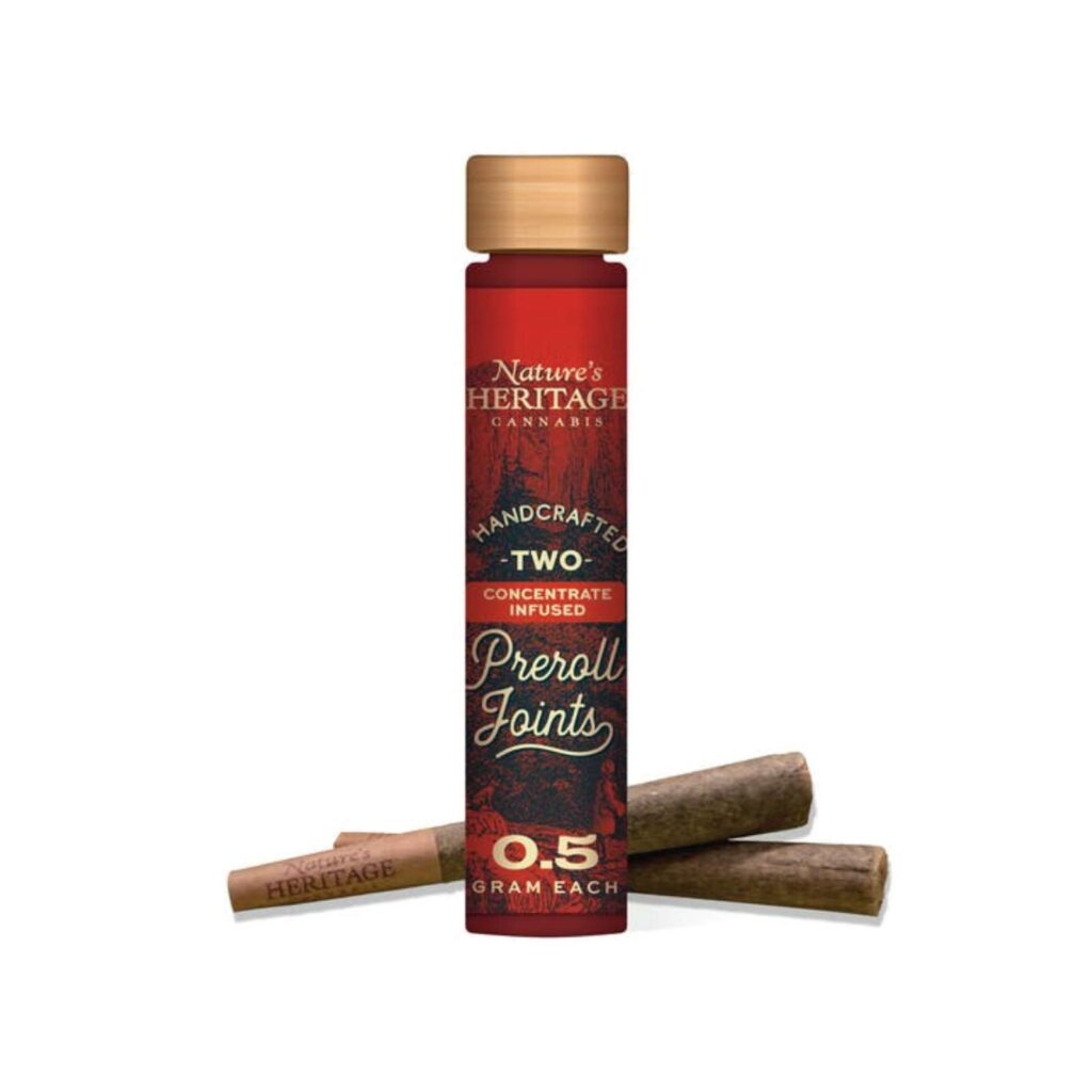Tall red Nature's Heritage cannabis product bottle with a wooden cap, surrounded by cinnamon sticks; text on label reads 'Two' and '0.5 gram each'.